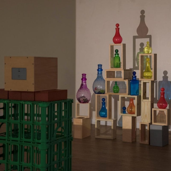 TTS Early Years Projector casting intricate shadow silhouettes of glass bottles and wooden blocks onto a wall, supporting creative arts, visual discrimination, and sensory exploration