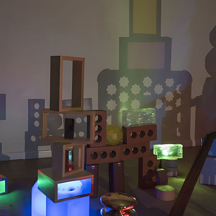 TTS Early Years Projector casting vibrant light and shadow projections onto a classroom wall using stacked loose parts and blocks, supporting STEAM learning and visual exploration