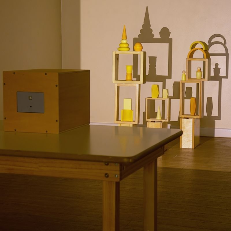TTS Early Years Projector on a classroom table casting large shadow projections of wooden shapes and objects, supporting visual perception and STEAM learning for children aged 3 and up
