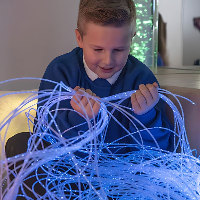 TTS Fibre Optic Tails held by a child, showing the blue-toned colour-changing sensory light strands in an active play setting