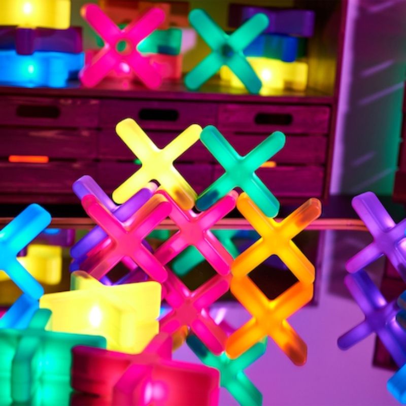 TTS Glow Crosses interlocked in a flat tessellated grid, glowing in multiple colours, showing the mathematical pattern-making and sequencing possibilities for early years EYFS learning