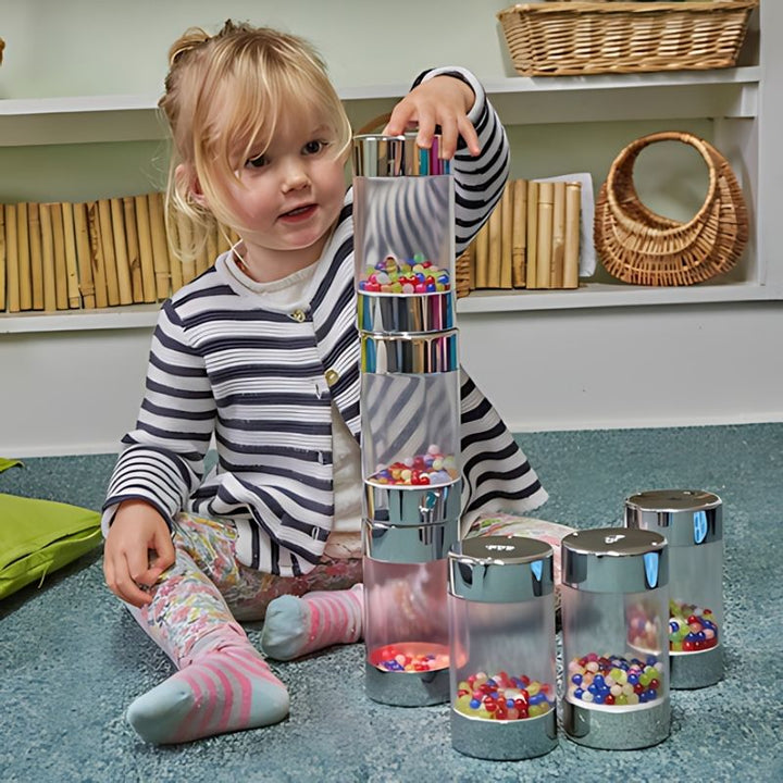 Child in striped top engaged in active play with TTS Illuminated Glow Roller Shakers, a multisensory toy for early years development