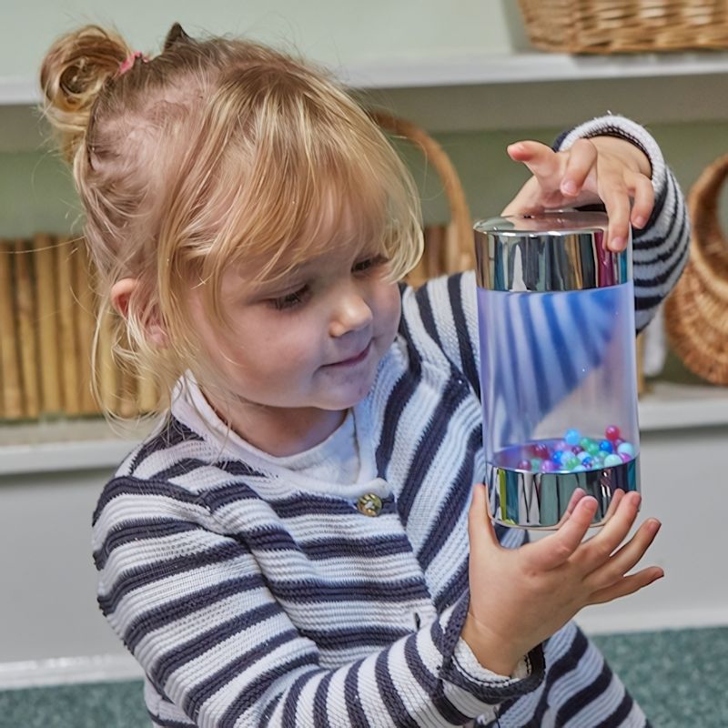 Child engaged in active play with TTS Glow Roller Shakers, focusing on the illuminated LED light for visual sensory stimulation