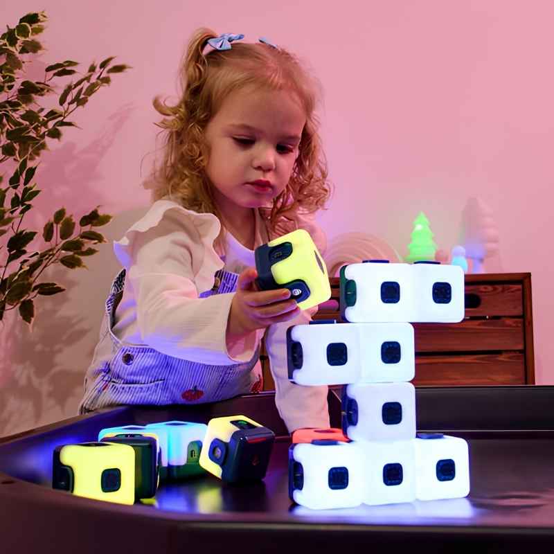 Young child stacking TTS Glow Sequencing Cubes on a light table, exploring colour and sequencing through sensory light-up play