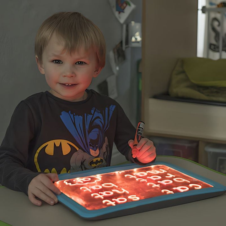 Boy engaged in mark-making on the TTS illuminated writing board, supporting fine motor skill development and early writing in a sensory environment