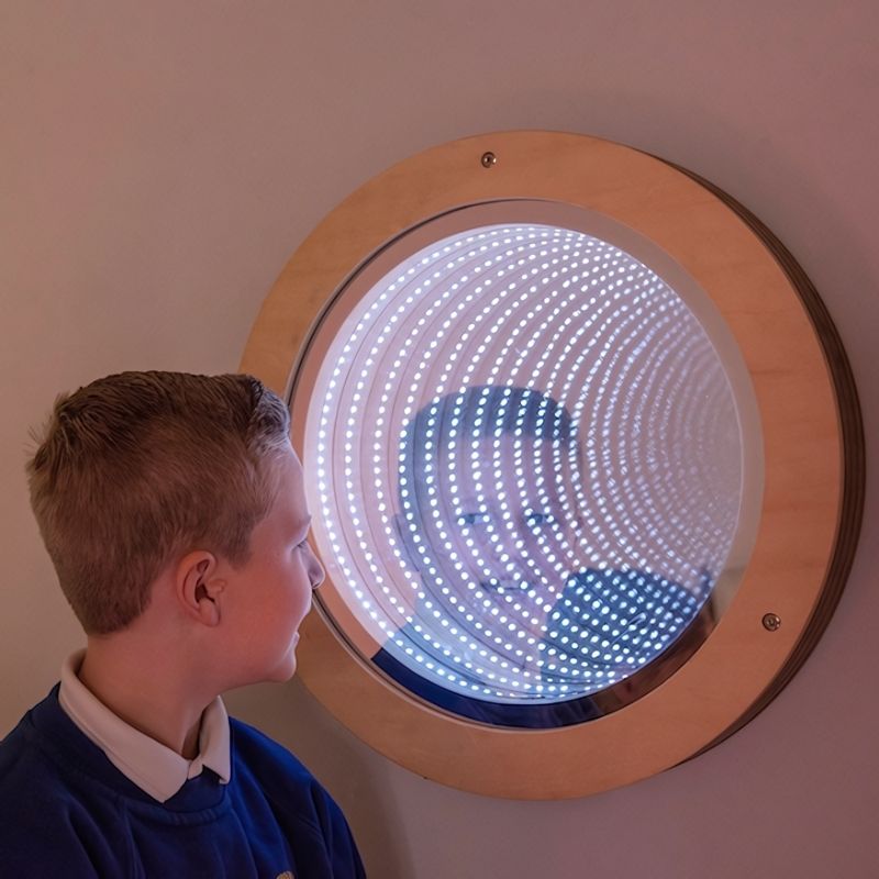 TTS circular infinity mirror mounted on wall in a sensory room, showing the glowing LED light tunnel effect