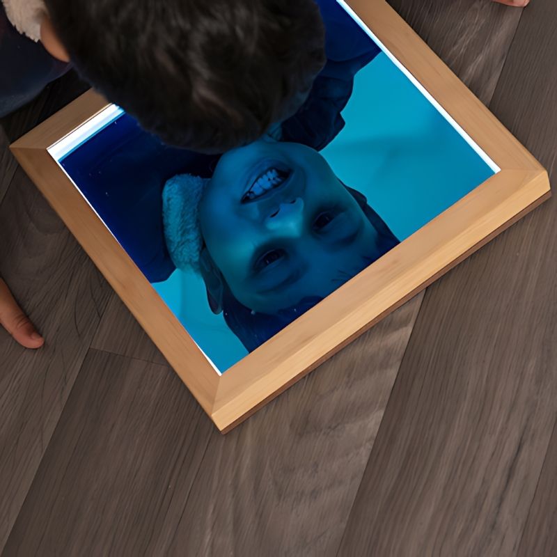 Child exploring their reflection in a TTS light up acrylic sensory mirror, supporting self-awareness and personal development in early years settings