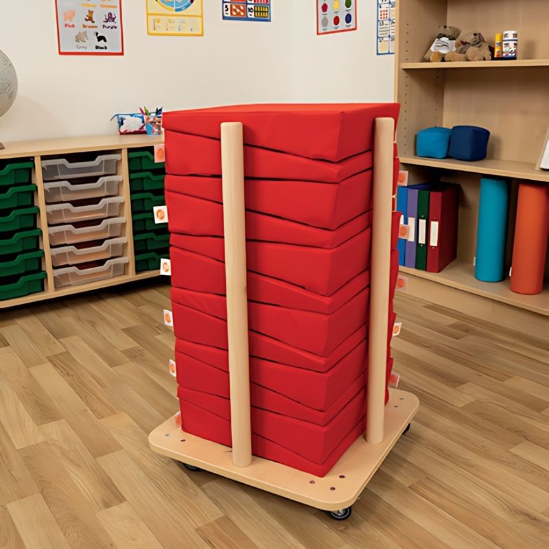 TTS Maxi Wedge posture cushion in red, shown in an indoor classroom setting demonstrating ergonomic floor seating for children