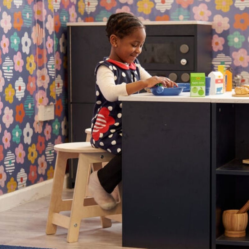 TTS Modern Living Mini Kitchen Stools with a child engaged in role play at the kitchen, showing the correct scale and height for early years imaginative play