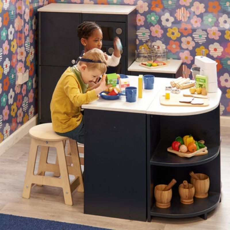 Two children sitting on TTS Modern Living Mini Kitchen Stools during collaborative role play, demonstrating social and language development in an early years setting