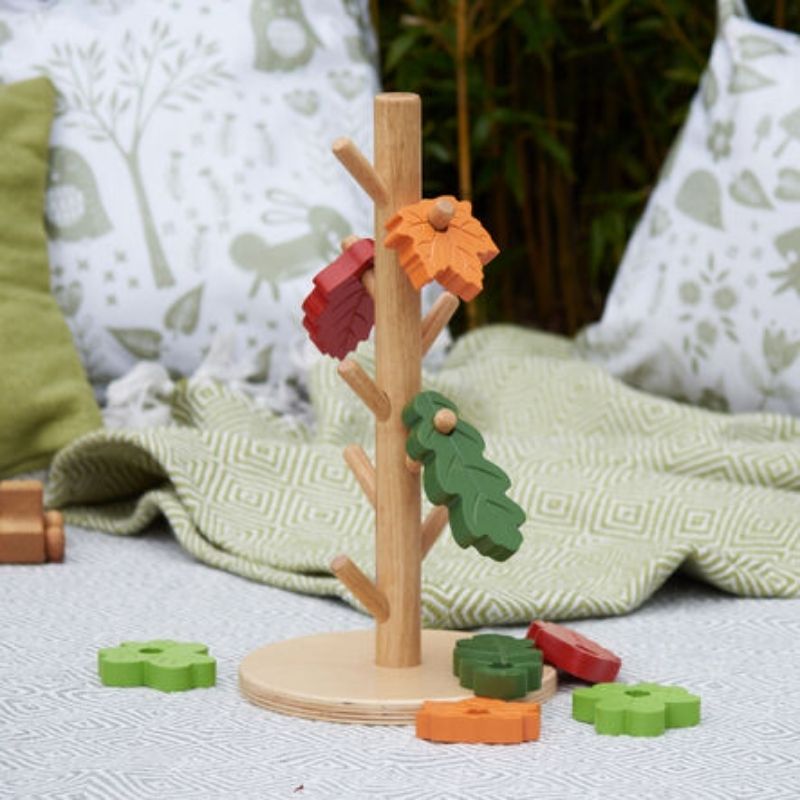 Close detail of the TTS Outdoor Posting Tree's rubber wood construction and leaf posting slots, supporting schematic development in toddlers