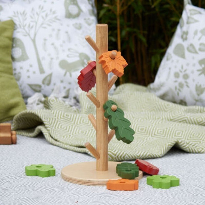 Close detail of the TTS Outdoor Posting Tree's rubber wood construction and leaf posting slots, supporting schematic development in toddlers