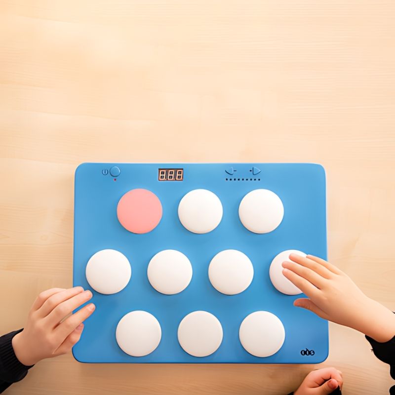 TTS Portable Light Up Reaction Wall Game positioned flat on a surface, with non-slip rubber button feet that protect floors and tables during active play