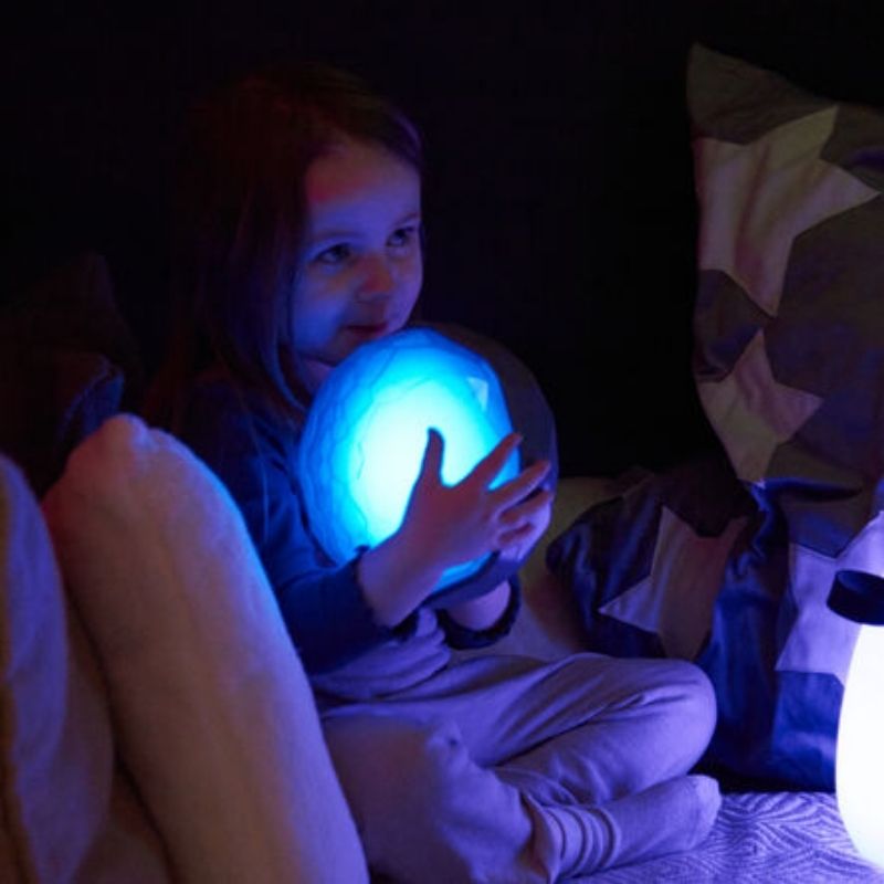 Child actively playing with TTS Light Up Recordable Domes in blue LED light, demonstrating the multi-sensory learning experience for early years and inclusive classrooms