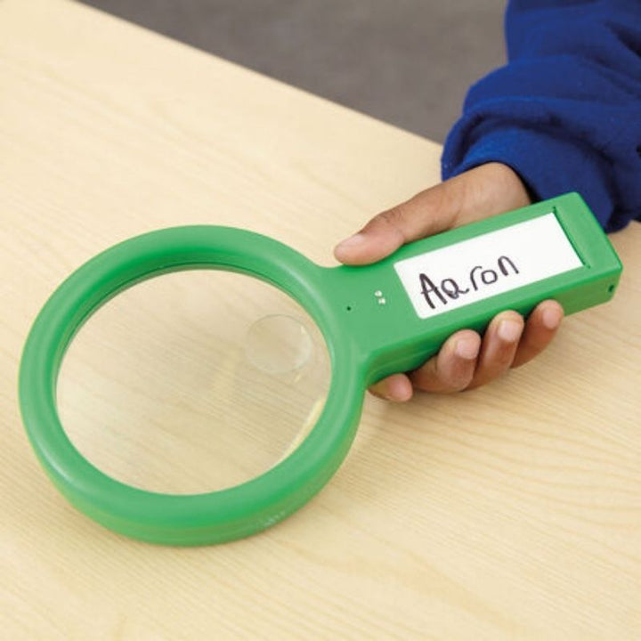 Child using a TTS Recordable Magnifying Glass to observe natural objects, supporting hands-on science learning and communication skills development for ages 4 and up