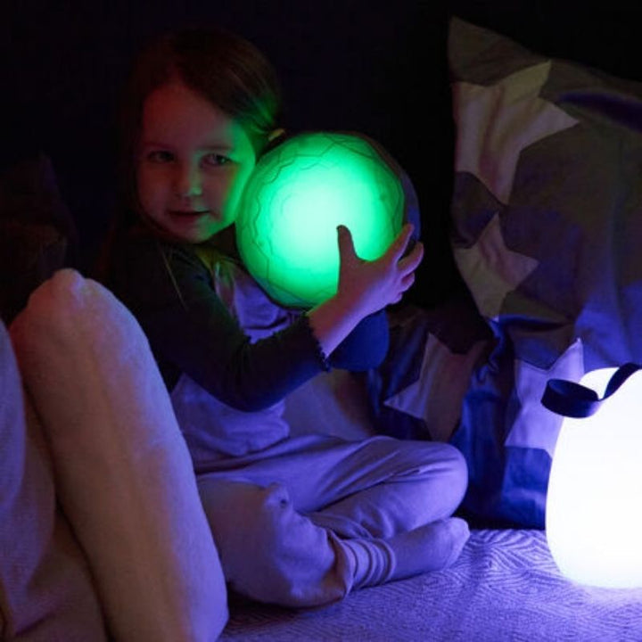 Child pressing a TTS Light Up Recordable Dome glowing green, demonstrating the cause-and-effect LED light response for sensory and motor development