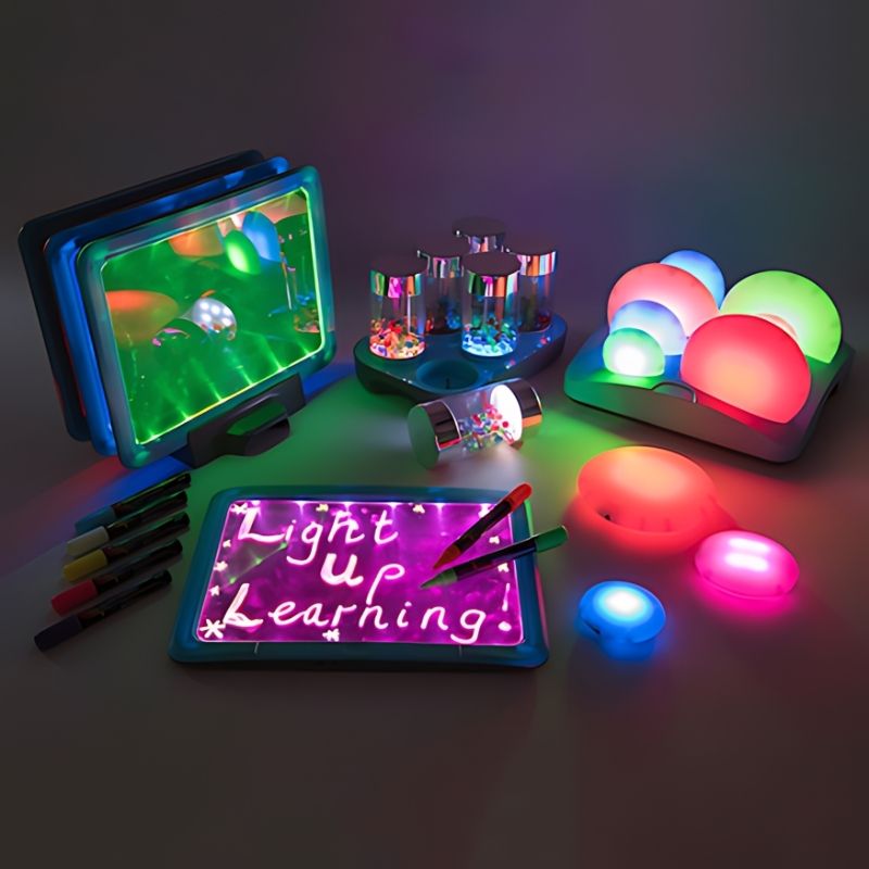TTS Sensory ICT Glow Set displayed in full, showing glow pebbles, rollers, illuminated writing boards and docking stations as a complete rechargeable sensory light resource collection