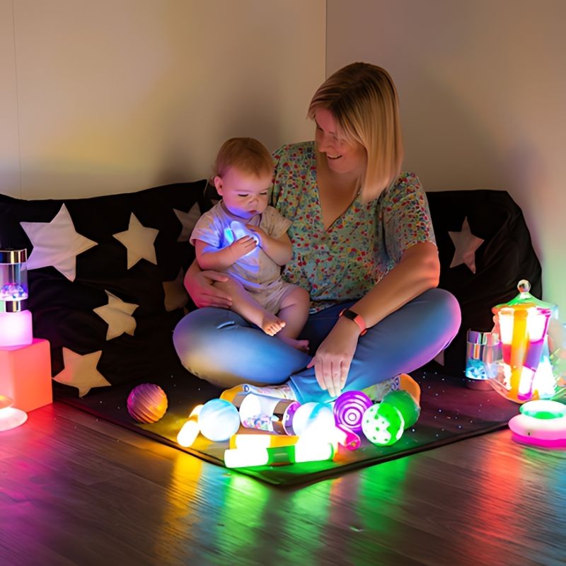 TTS Sensory Light Up Glow Collection shown with a parent and child exploring glow toys together, demonstrating light-up sensory play