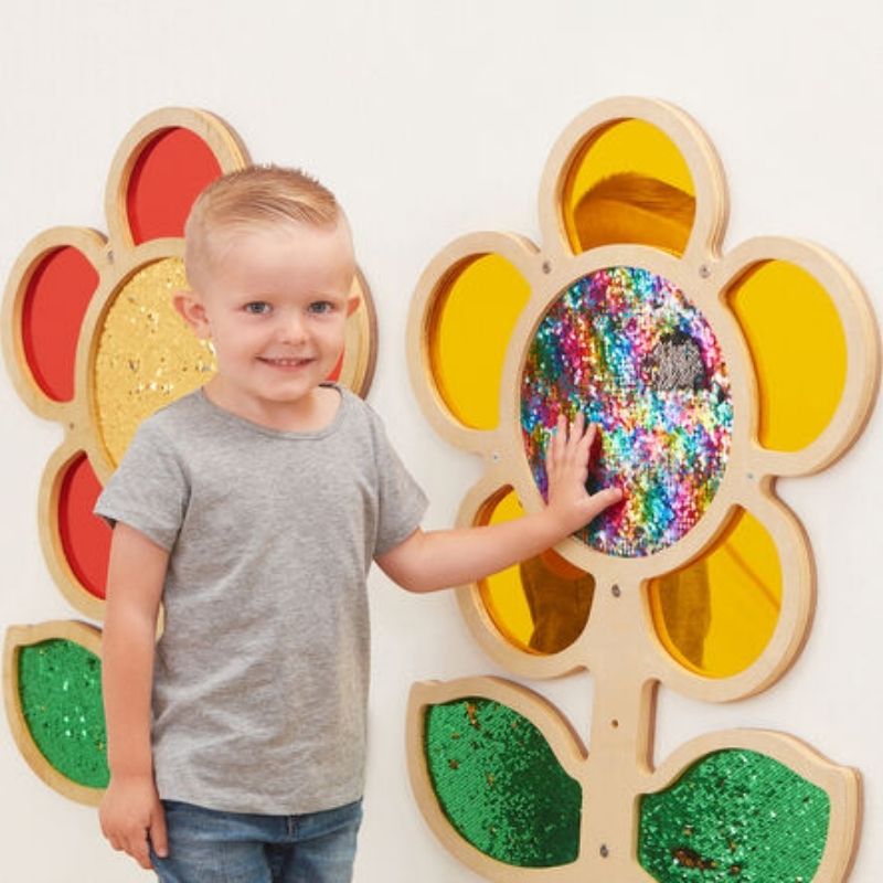 Child touching TTS yellow sequin daisy frame and stroking mermaid sequins to reveal colour change - sensory wall panel supporting pincer grip and hand-eye coordination