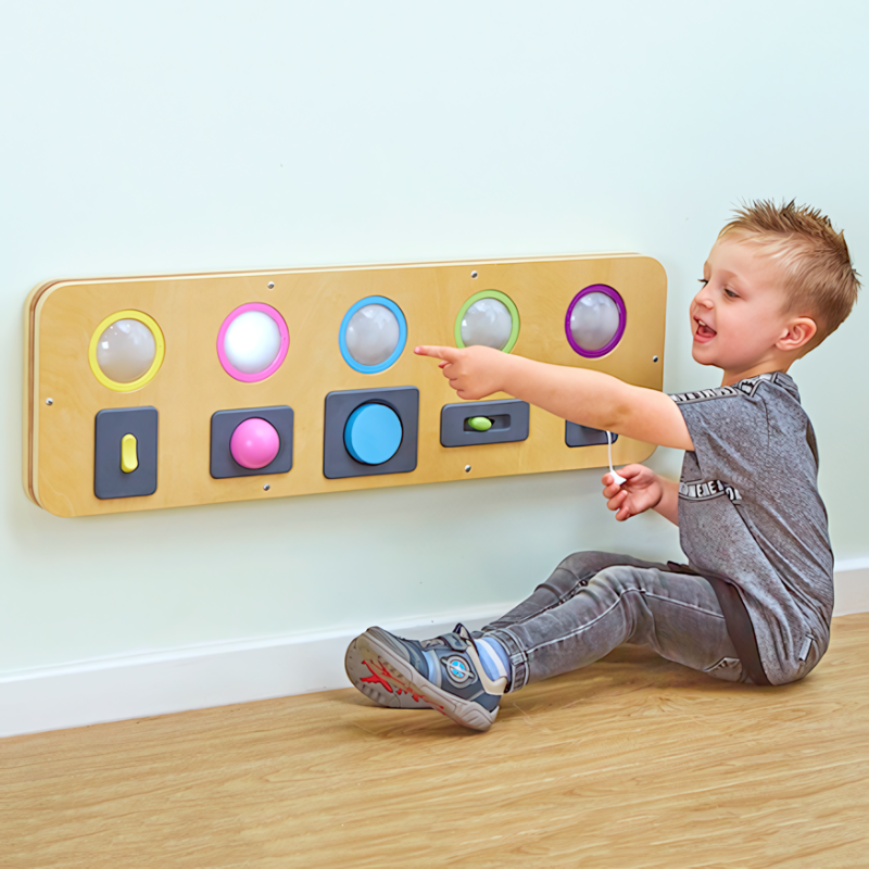 TTS Switch and Press Fine Motor Board in use by a young boy, demonstrating cause-and-effect interaction and hand-eye coordination development