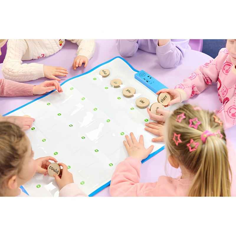 A group of young children seated on the floor using the TTS Interactive Talking Mat for a collaborative floor-based speaking and language activity with wooden word tokens