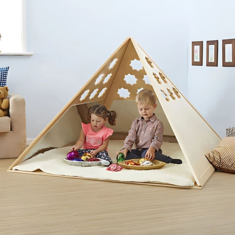 Three children playing inside the TTS Wooden Pyramid Den, a sensory den for kids featuring mirrored walls and customisable cut-out shapes