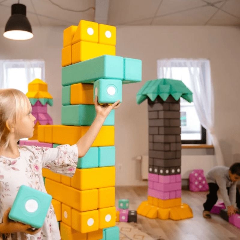 Two children building together with TUKI Big Magnetic Foam Blocks Smart 240, demonstrating collaborative sensory play and social communication development