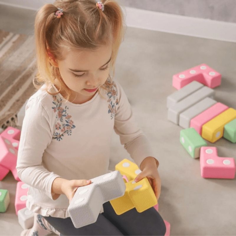 Girl building with the TUKI Regular Magnetic Foam Blocks 26-element set, showing collaborative and creative magnetic construction play for early years children
