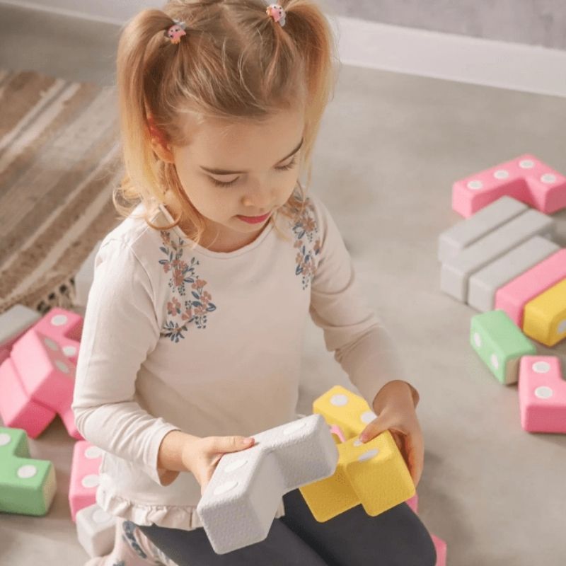 Top view of child actively building with the TUKI Regular Magnetic Blocks 48 Elements set, showing open-ended magnetic foam construction play with the group-scale neodymium block set