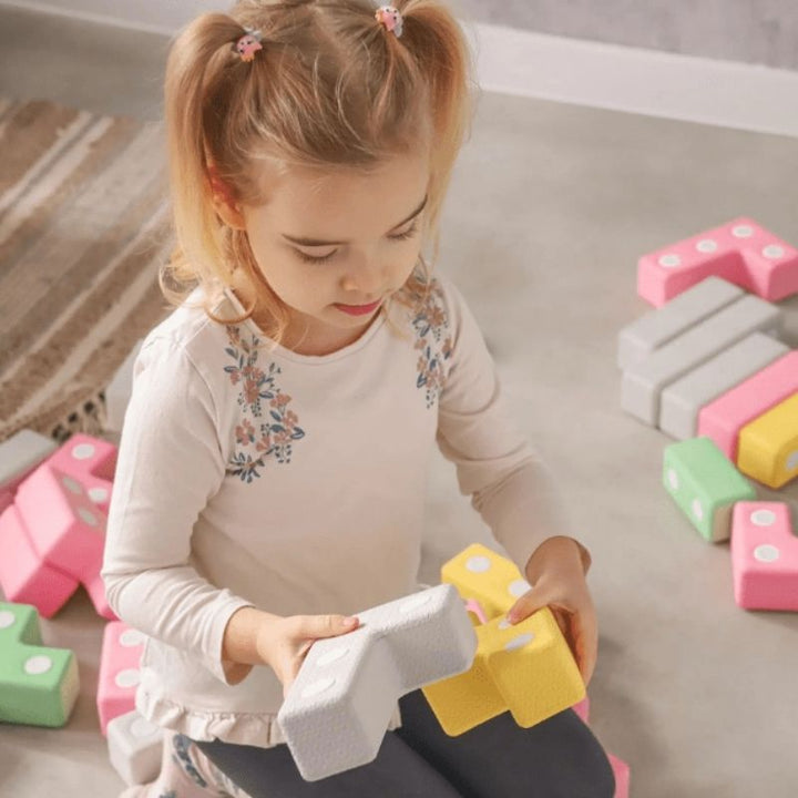Top view of child actively building with the TUKI Regular Magnetic Blocks 48 Elements set, showing open-ended magnetic foam construction play with the group-scale neodymium block set