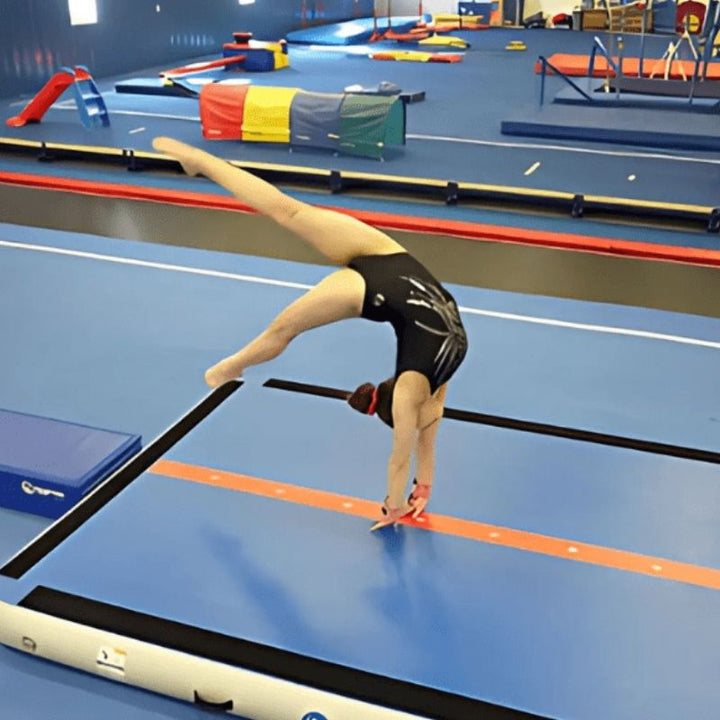 Girl actively tumbling on the Tumbl Trak Air Floor PRO, demonstrating the 8-inch double-wall bouncy surface that supports back handsprings, round-offs, and connected gymnastics tumbling passes on any floor surface