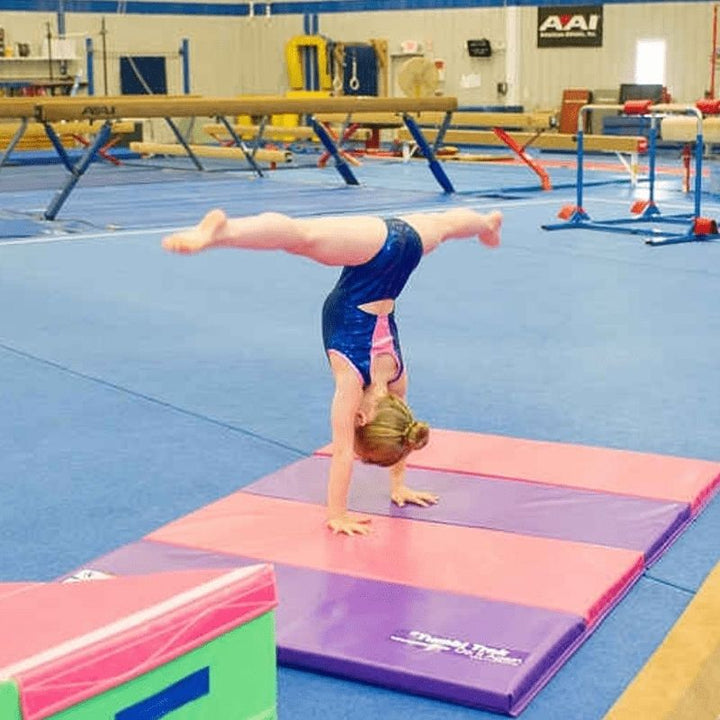 Young child actively tumbling or rolling on the Tumbl Trak Jack and Jill Mat, demonstrating the dual-layer foam surface designed for forward rolls, backward rolls, and early gymnastics skill development for young children
