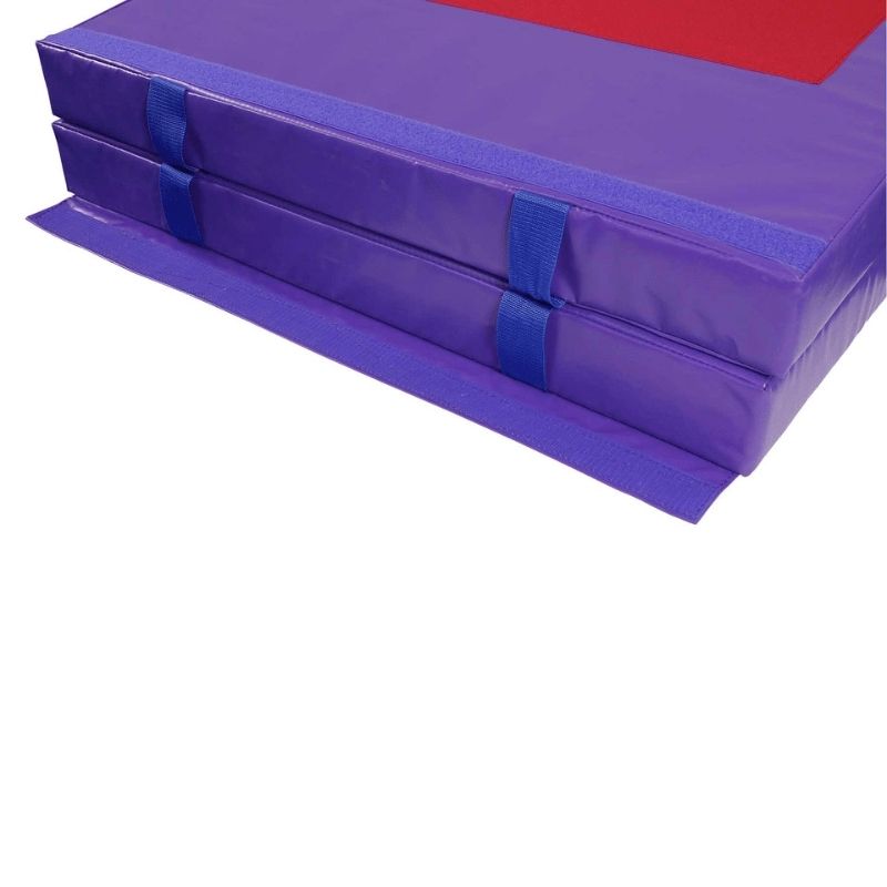 Corner view of the Tumbl Trak Jr. Practice Mat in Purple showing the 18 oz. knife-coated vinyl edge construction, reinforced handle, and non-skid base of the compact gymnastics crash mat designed for home training and smaller gym spaces