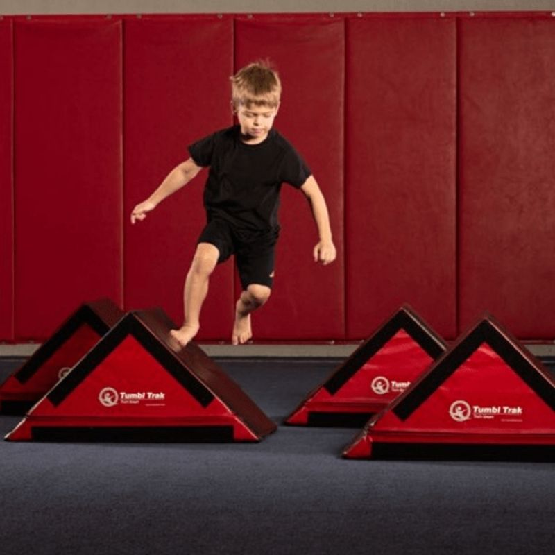Child actively navigating the Tumbl Trak Ninja Starter Bundle obstacle course, demonstrating agility, balance, and motor planning development through indoor foam ninja obstacle training