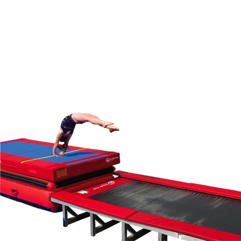 Young girl performing a back flip or tumbling pass on the Tumbl Trak Porta Trak, showing the foldable aluminium gymnastics tumbling track in active use for skill development in a gymnastics club or mobile programme setting