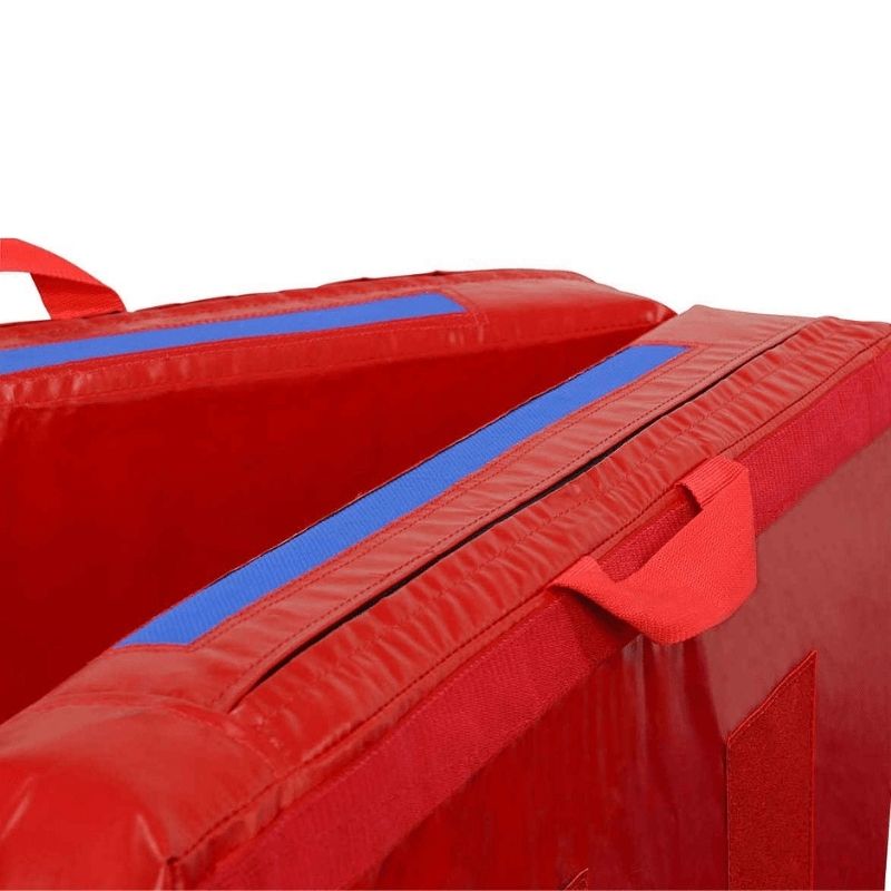 Corner view of the Tumbl Trak Practice Mat in Red and Royal Blue showing the reinforced handle construction and vinyl edge detail of the gymnastics crash mat for bars, beam, tumbling, and vaulting stations