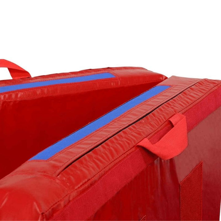 Corner view of the Tumbl Trak Practice Mat in Red and Royal Blue showing the reinforced handle construction and vinyl edge detail of the gymnastics crash mat for bars, beam, tumbling, and vaulting stations
