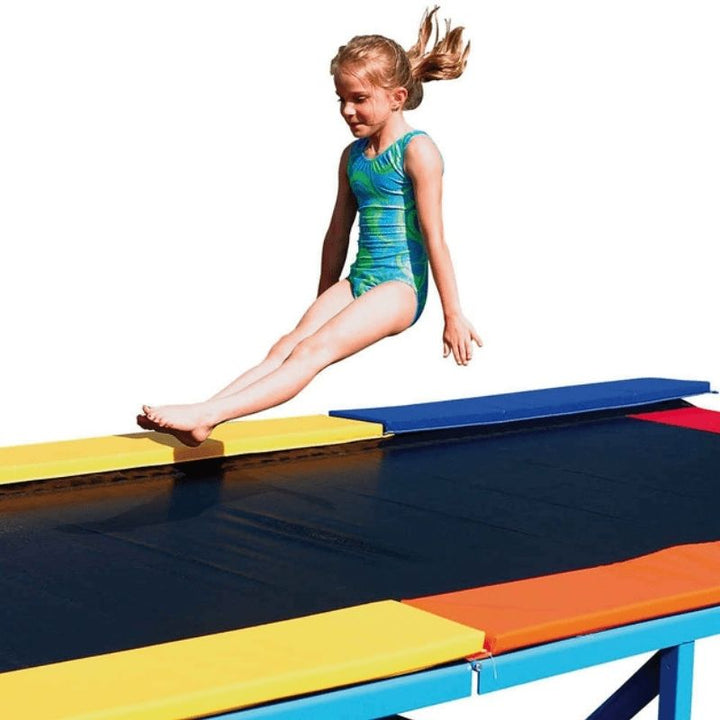 Close-up of a girl mid-jump on the Tumbl Trak Recreational Tumbling Track, demonstrating the safe, low-impact spring surface used for gross motor development and beginner tumbling skill building