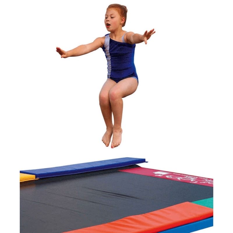 Girl jumping on the Tumbl Trak Recreational Tumbling Track, showing the bouncier, gentler rebound of the soft spring gymnastics track for preschool and recreational gymnastic programmes
