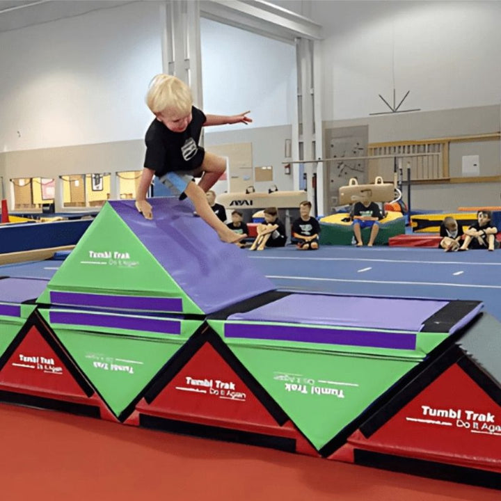 Boy balancing on the Tumbl Trak Slanted Ninja Steps in cube box configuration, demonstrating proprioceptive input, postural control, and balance development for gymnastics, OT therapy, and inclusive PE programmes