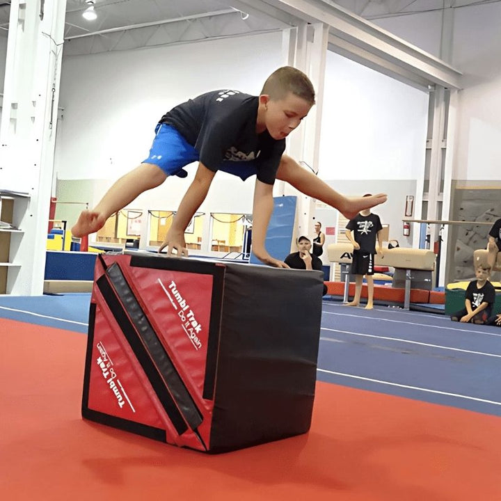 Boy hopping over the Tumbl Trak Slanted Ninja Steps in hurdle configuration, demonstrating the jumping and directional movement agility training the foam ninja obstacle steps support for school and home use