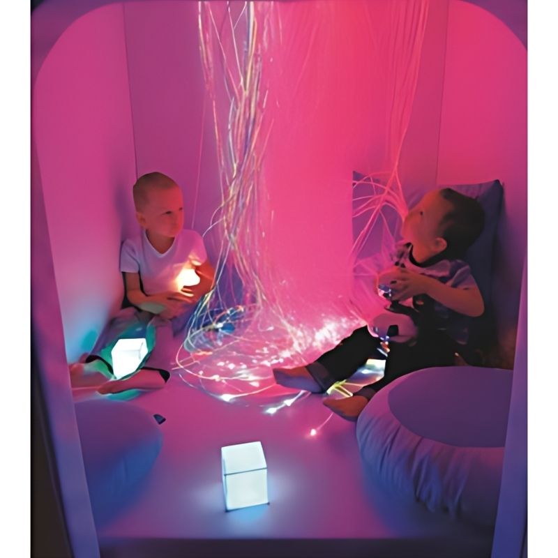 Child engaged in sensory play inside the Wesco Sensory Cabin with purple lighting, demonstrating this portable sensory room cabin as a calm corner in a therapy or school setting