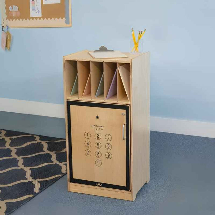 Whitney Brothers Cell Phone Locker WB1217 in a K-8 classroom setting, showing the locking door with cell phone graphic, open folder compartment above, and natural birch finish