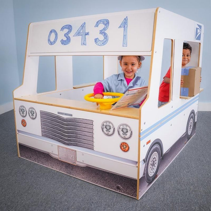 Front view of the Whitney Brothers Imagination Truck with two children in driver and passenger positions, showing the windshield dry erase board and realistic front grill exterior details