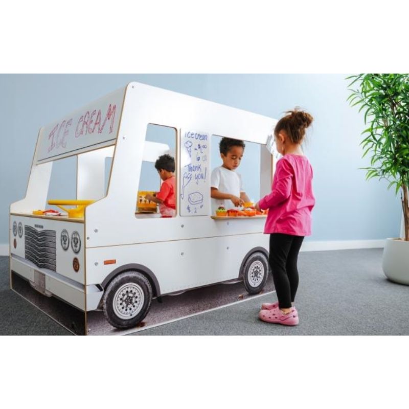 Three children engaged in dramatic play with the Whitney Brothers Imagination Truck, showing the serving counters on the side panel and the dry erase board customisation in use