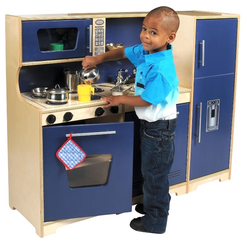 Child actively playing at the Whitney Brothers Monaco Combo Kitchen Playset, a space-saving all-in-one wooden play kitchen for classrooms and home