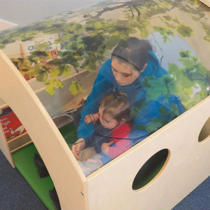 Adult and child together at the Whitney Brothers Nature Reading Haven with optional floor mat, showing adult supervision visibility through the transparent tree canopy acrylic roof