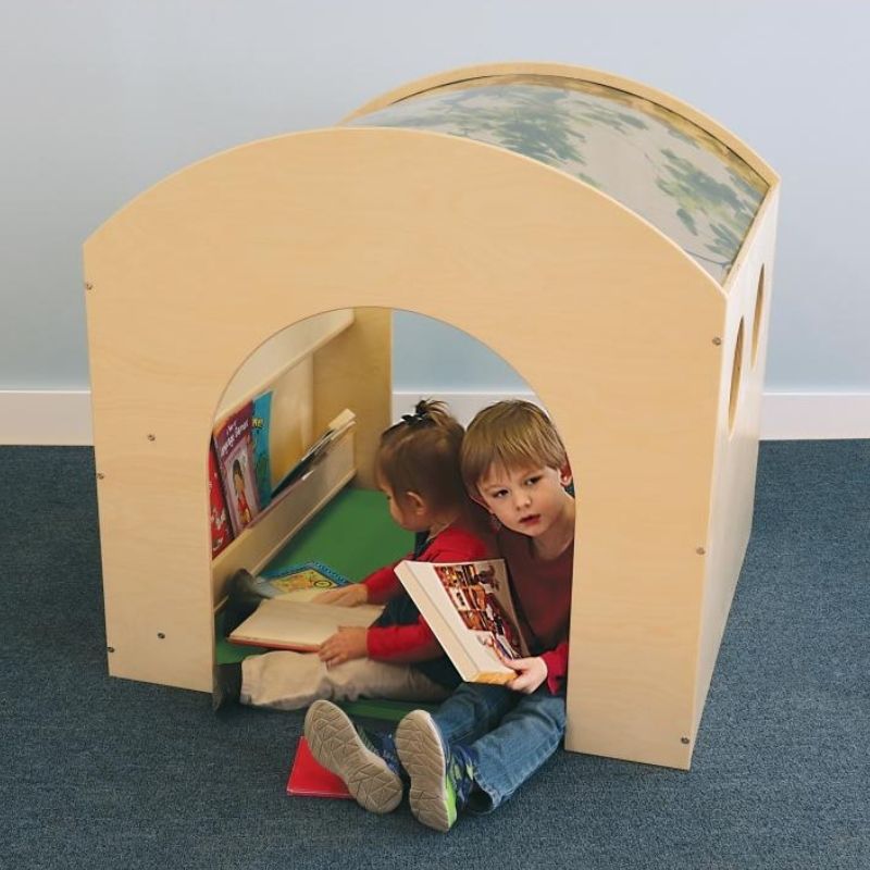 Two children playing inside and beside the Whitney Brothers Nature Reading Haven with optional Green Floor Mat, showing the biophilic quiet space reading nook in classroom use