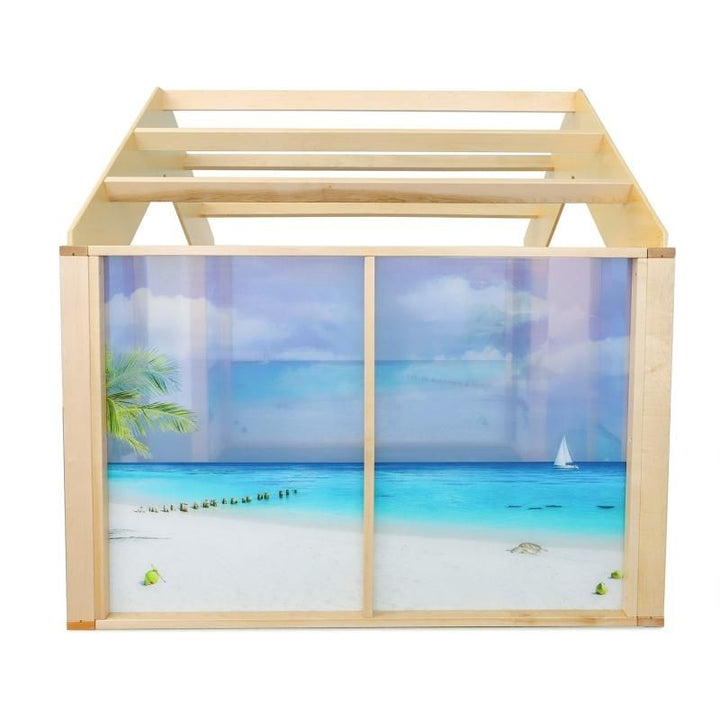 Side view of the Whitney Brothers Nature View Play Beach House showing the turquoise ocean and sandy beach scene on the shatterproof acrylic panels and the open pergola-style roof above