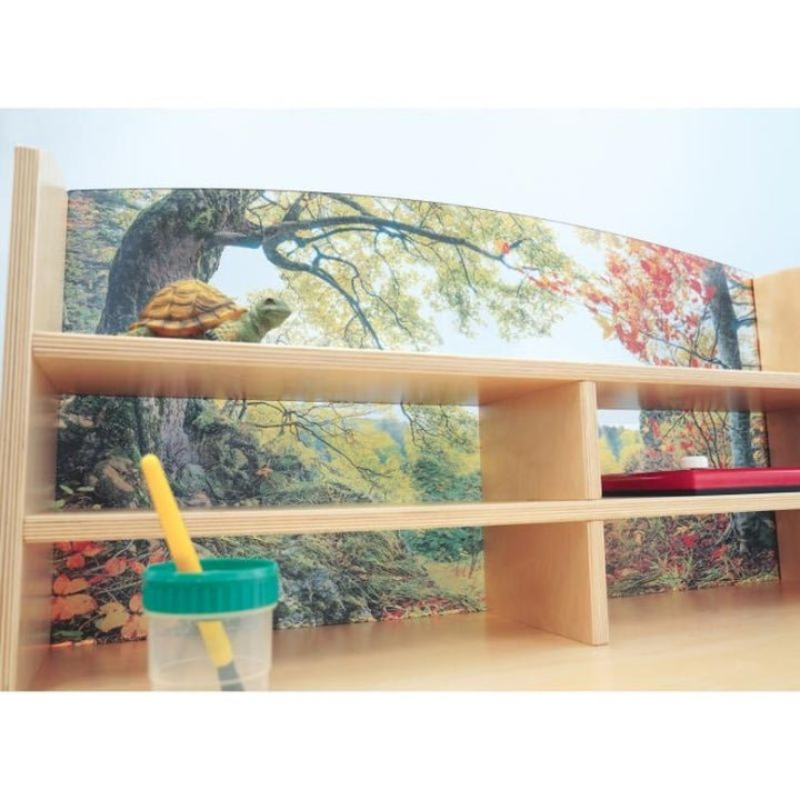 Close-up view of the Whitney Brothers Nature View Writing Center showing the forest scene detail printed on the shatterproof acrylic back panel and the storage compartments below the desk